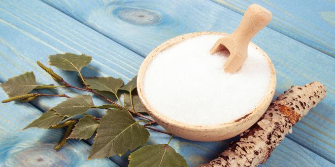 Birch sugar on blue wooden background.