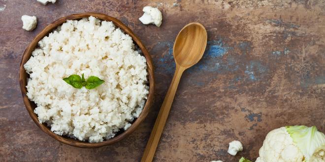 A wooden bowl filled with cauliflower rice.