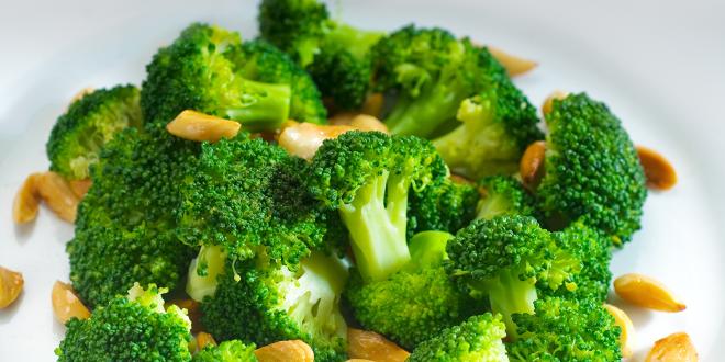 a bowl of broccoli and chopped nuts