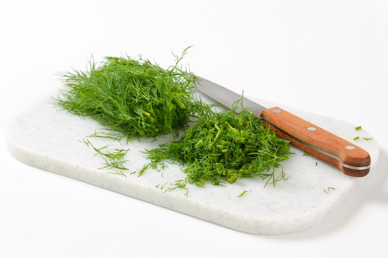 Sprigs of fresh dill on a cutting board